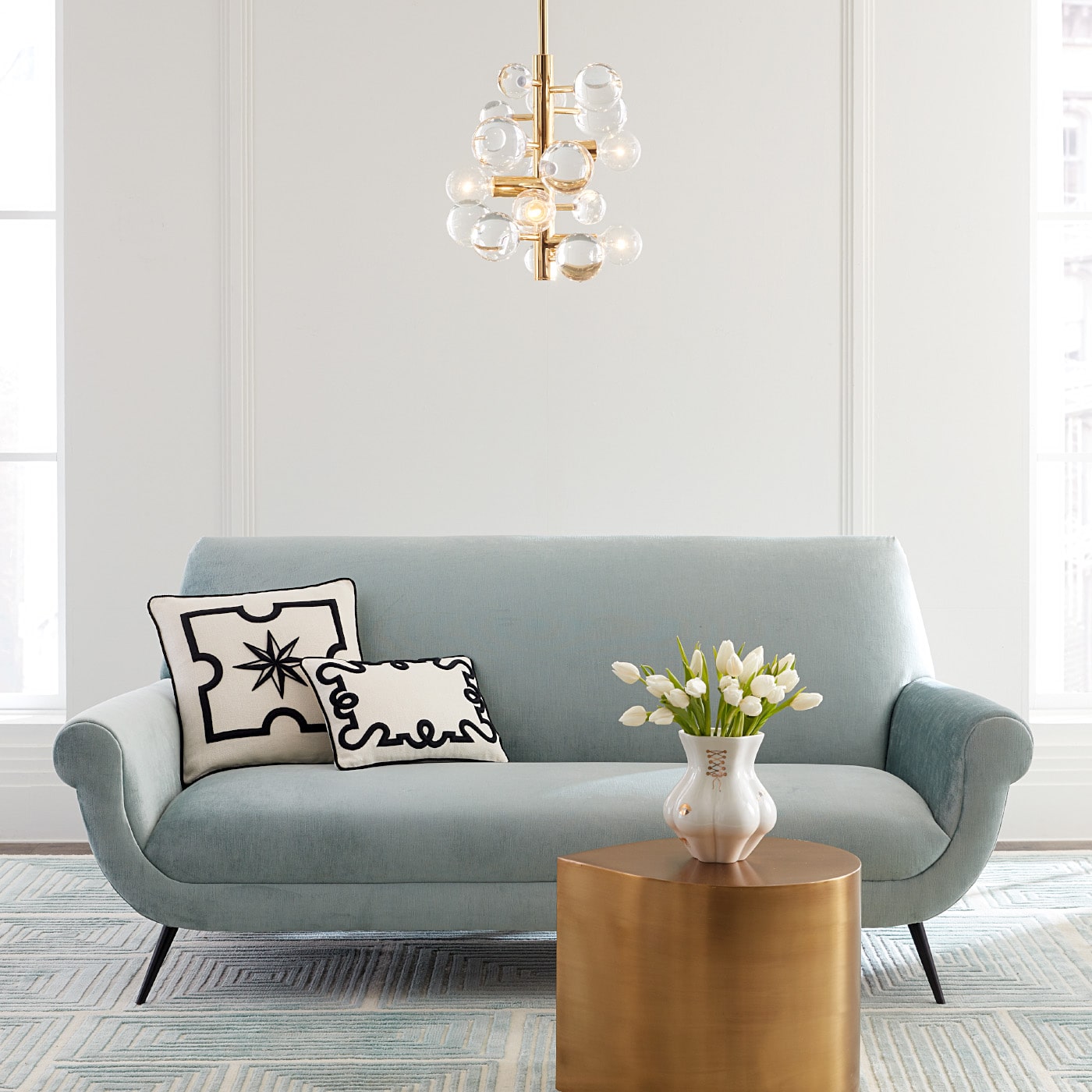 gilded kiki's derrier vase brass teardrop table marcello apartment sofa - styled view