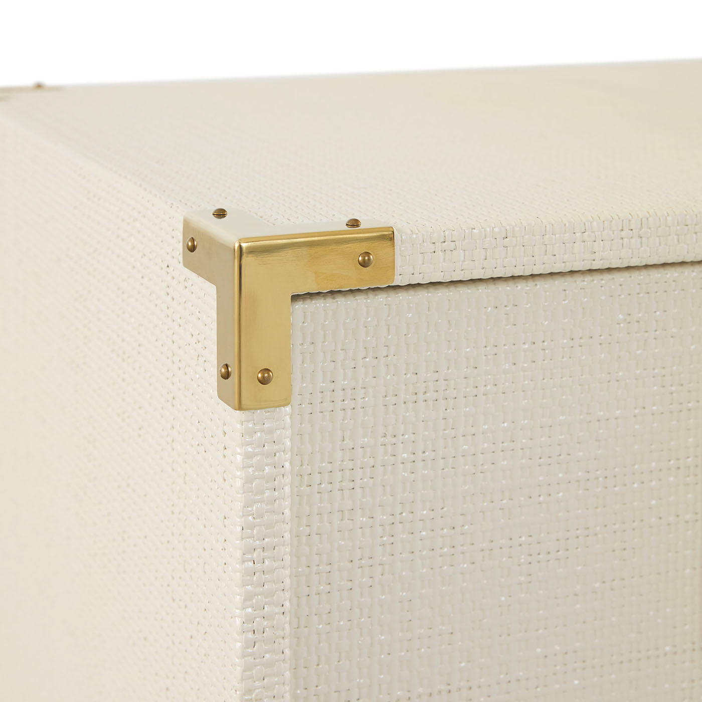 Close-up of a gold bracket on a textured white surface
