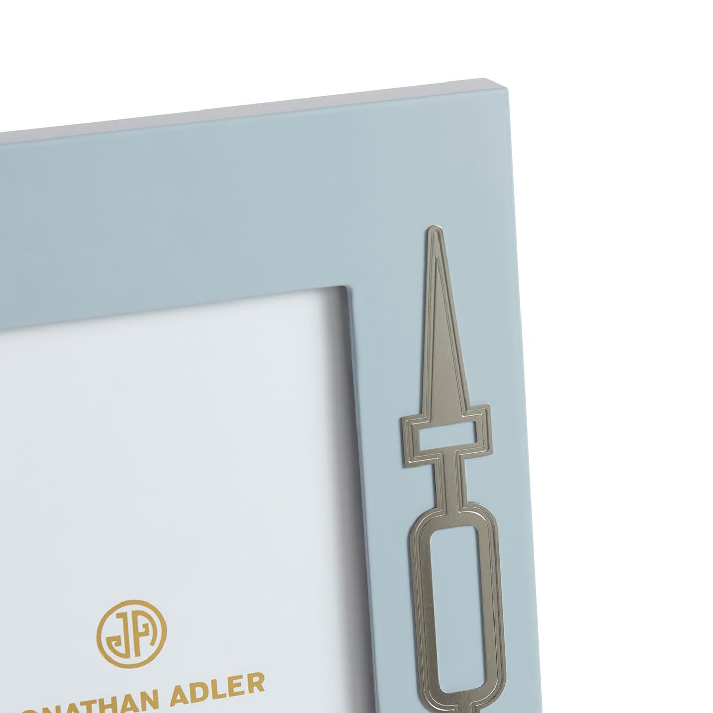 Metallic bookmark with a unique design on a light blue card, featuring the brand 'Jonathan Adler'.