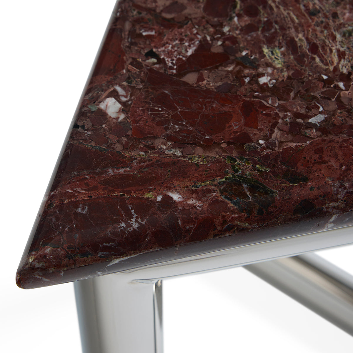 Close-up of a triangular table corner with a polished dark red-brown marble top showing natural veining, supported by a shiny silver metal frame on a white background.