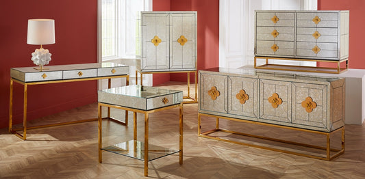 Delphine collection features bars, desks, dressers, credenzas, and side tables made from antiqued mirror with signature jewel-like quatrefoil accents in polished brass gold finishes.