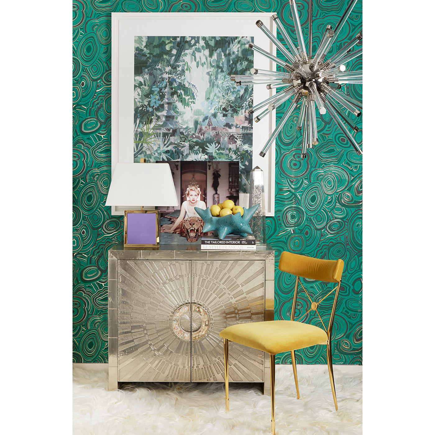 Decorative interior with a metallic console table, yellow chair, and green patterned wallpaper.