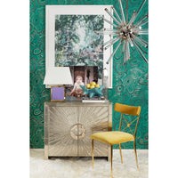 Decorative interior with a metallic console table, yellow chair, and green patterned wallpaper.