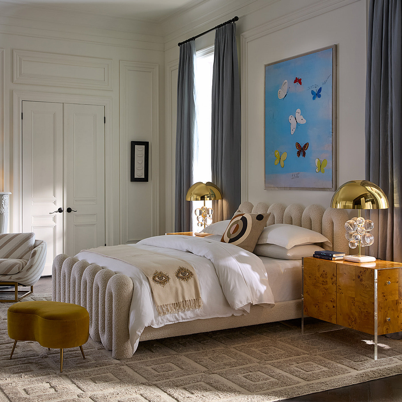 Beige blanket with embroidered eyes on a bed in a bedroom setting decor