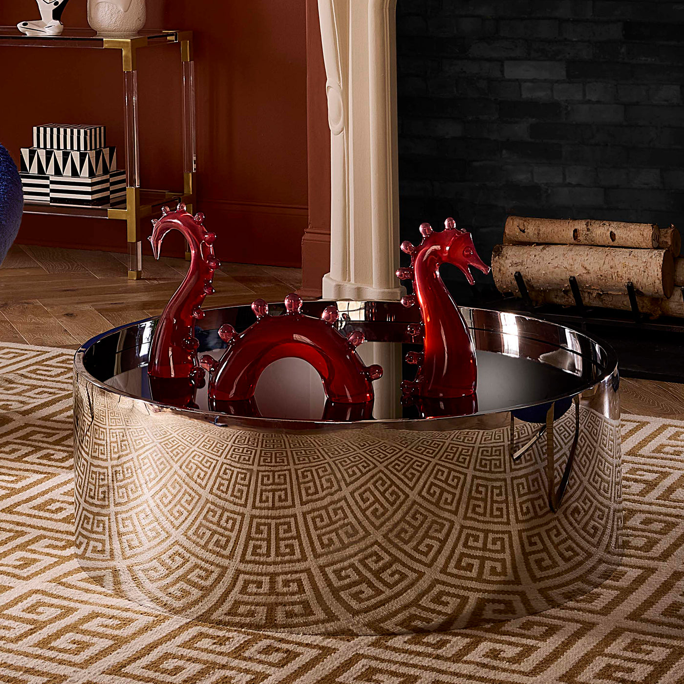 Decorative bathtub with red dragon-like fixtures in a room with a dark wall and wooden floor.