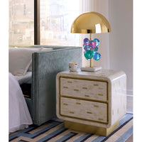 Neatly arranged bedroom with a nightstand, lamp, and decorative items.