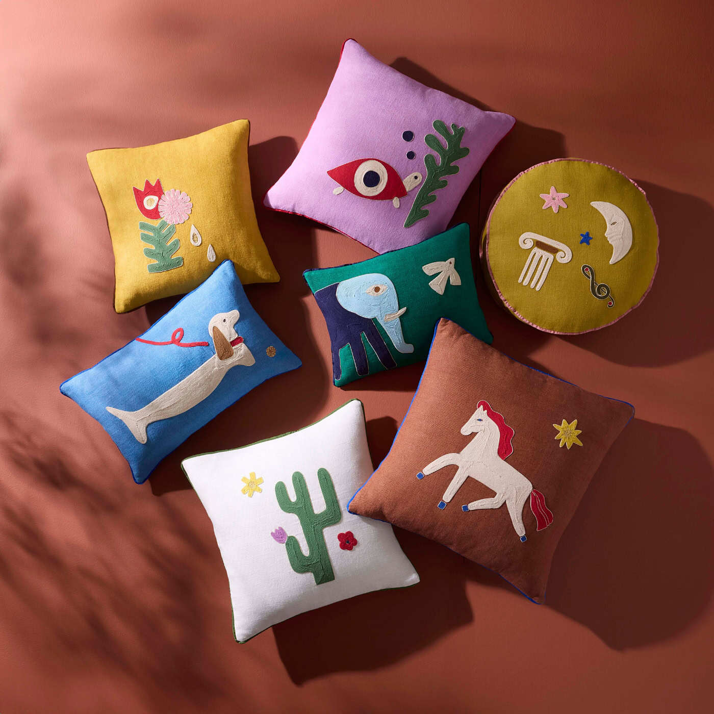Colorful decorative pillows with various designs on a brown background