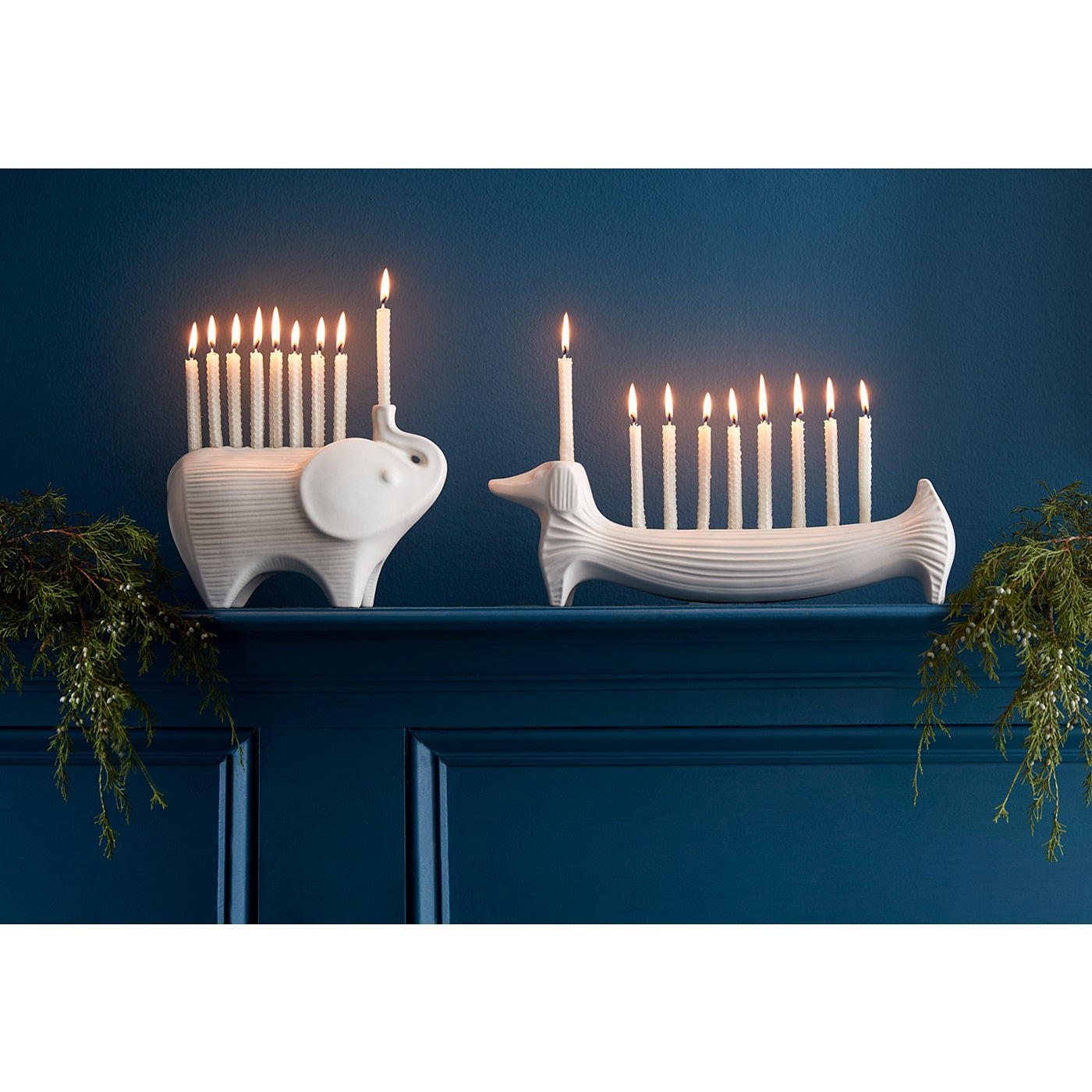 ceramic elephant and dachshund menorahs with candles - styled view