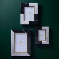 Three decorative picture frames with marble and black accents on a green background