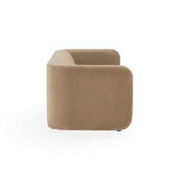 A modern low-profile armchair with a rounded rectangular silhouette, upholstered in a warm taupe fabric, shown from a three-quarters angle on a white background.