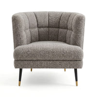 A modern barrel-style accent chair upholstered in a textured gray bouclé fabric, featuring channel-tufted detailing on the backrest and seat, black tapered legs, and gold-tone metal foot caps, shown against a plain white background.