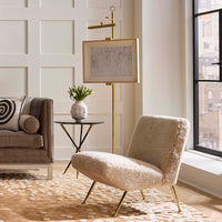 Modern living room with a beige armchair, sofa, and decorative elements.