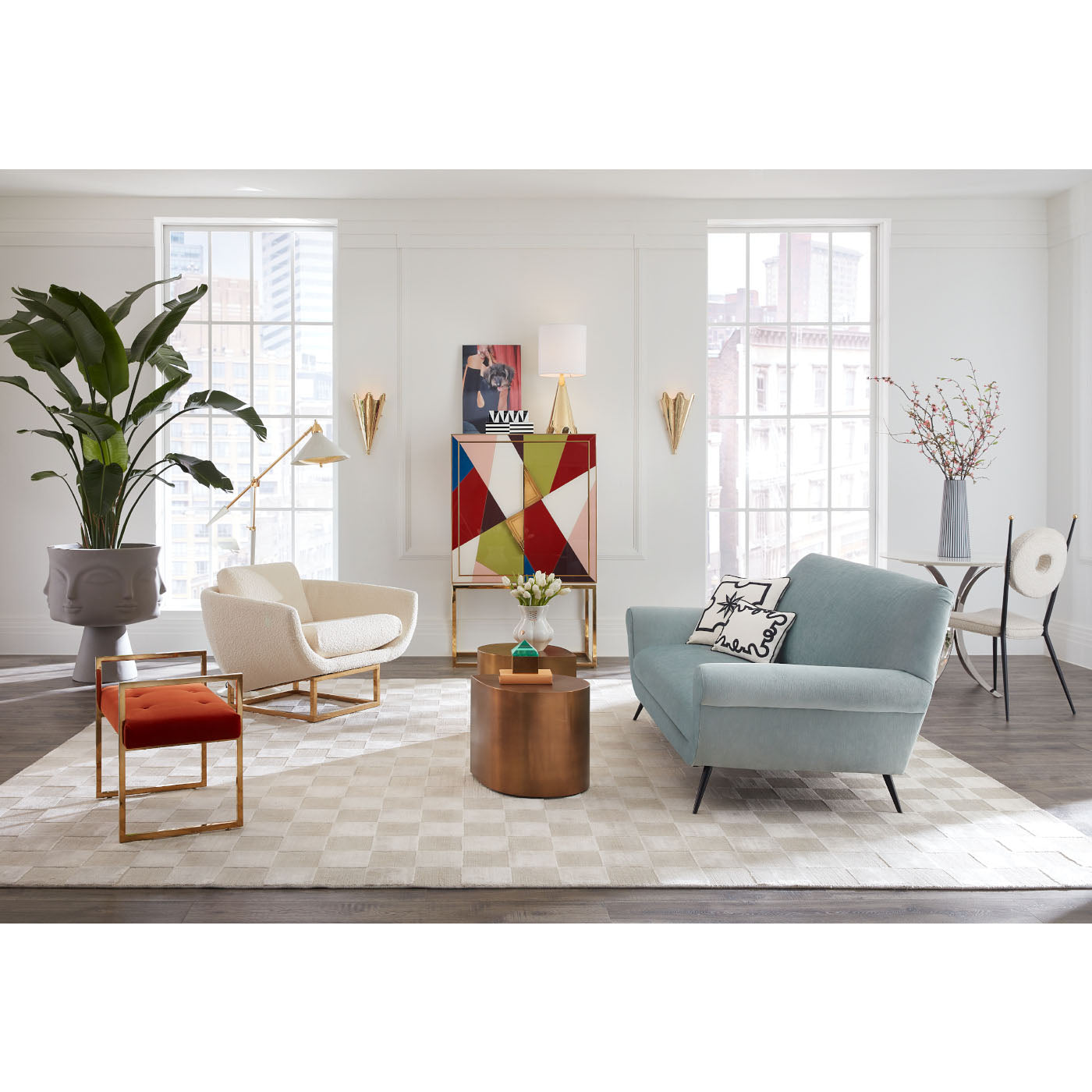 Modern living room with a blue sofa, white armchair, and colorful abstract art on the wall.