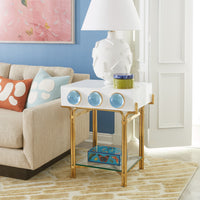 Modern side table with gold legs and white marble top in a living room setting.