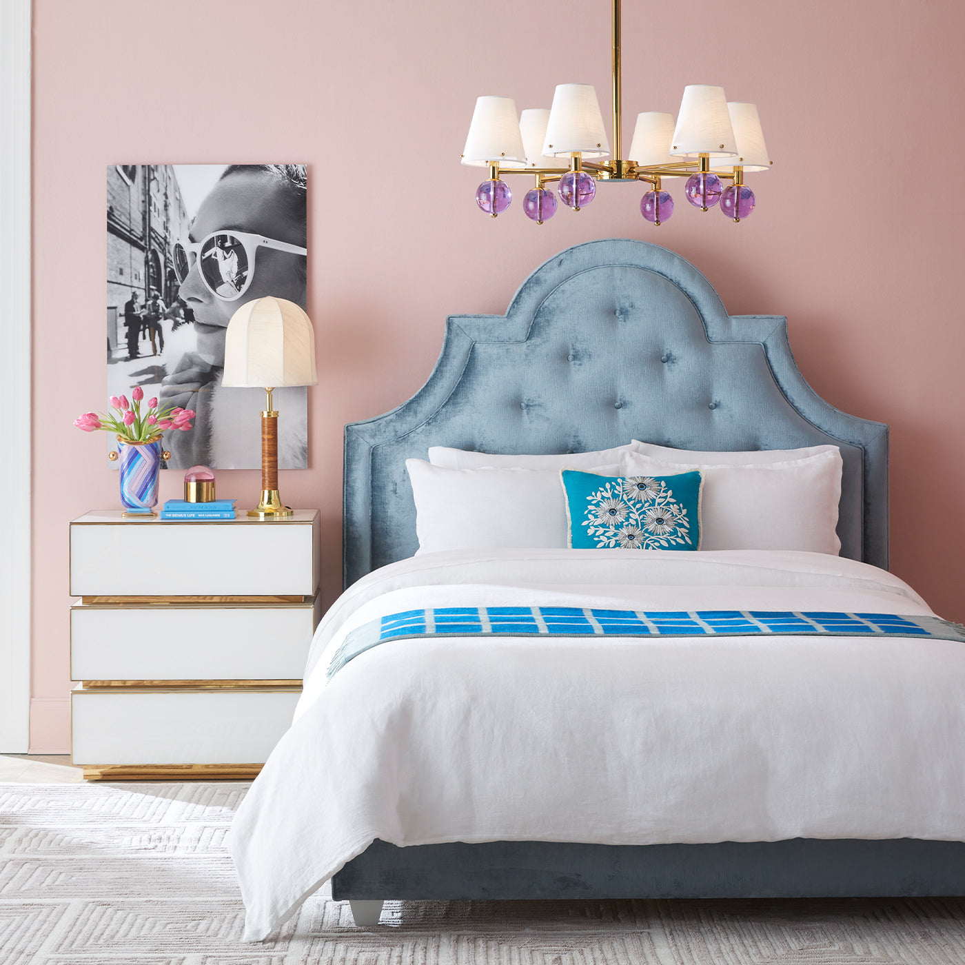 Neatly made bed with blue and white bedding in a bedroom setting.