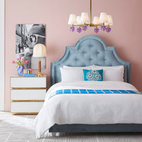 Neatly made bed with blue and white bedding in a bedroom setting.