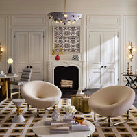 Modern living room with two beige chairs, a coffee table, and decorative items.