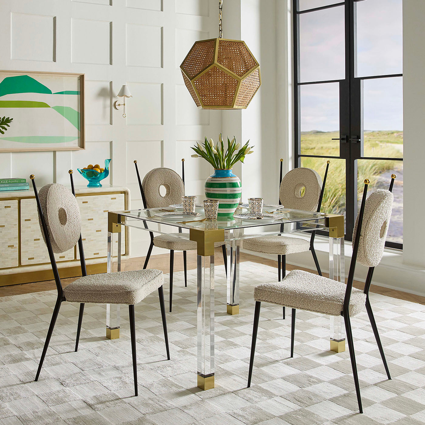 Dining room with a glass table and chairs in a modern interior setting.