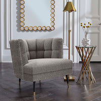 Gray upholstered chair in a stylish room with a mirror and lamp.