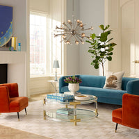 Modern living room with blue sofa, orange armchair, and decorative elements.