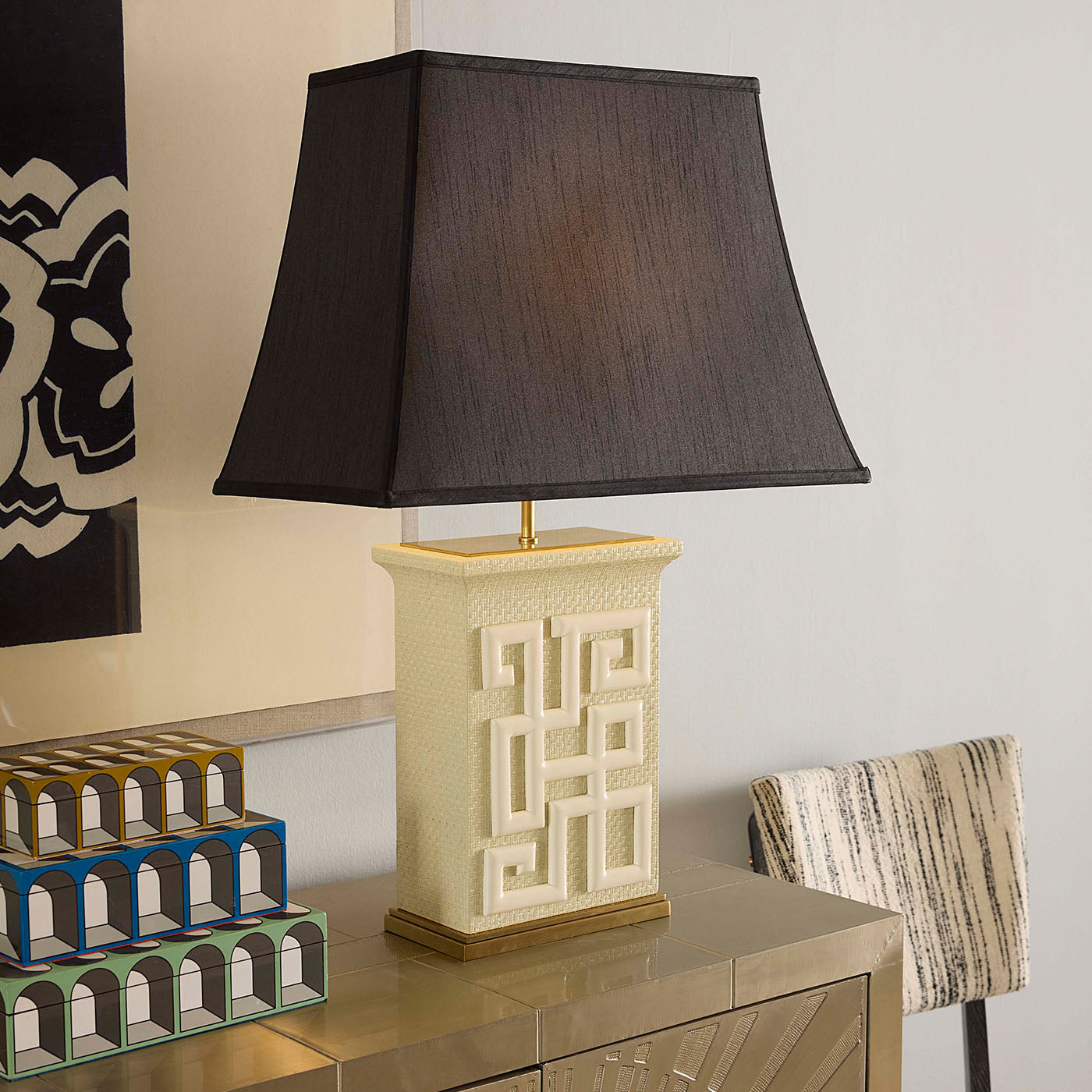 Decorative table lamp with a geometric base on a reflective surface.