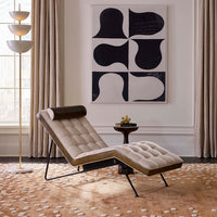 Modern lounge chair in a stylish living room with abstract art on the wall.