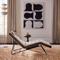 Modern lounge chair in a stylish living room with abstract art and decor.
