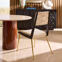 Dining room with a modern table and chair, featuring a decorative cabinet in the background.