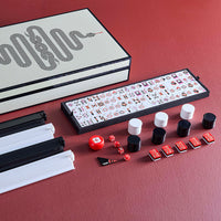 Mandarin duck mahjong set with tiles, dice, and carrying case on a red surface