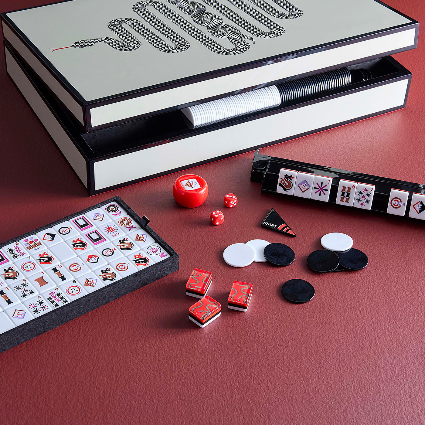 Mahjong game set with tiles and dice on a red surface