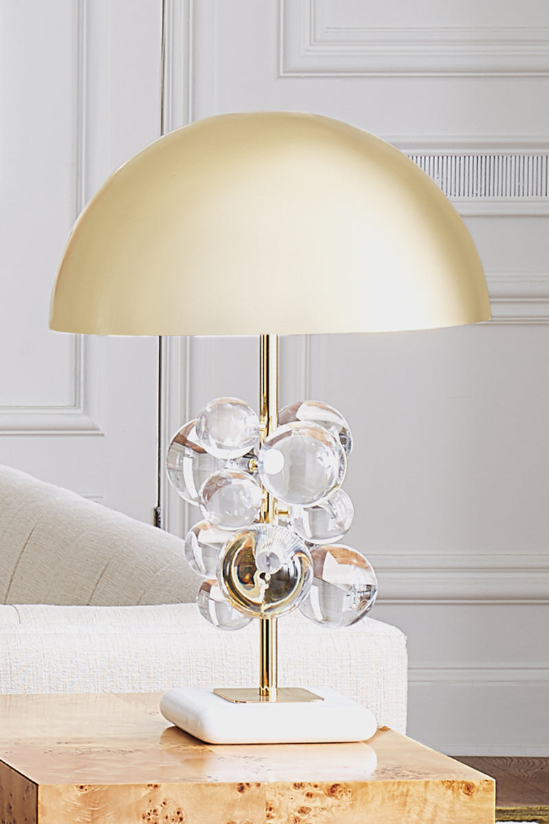 Brass table lamp with clear acrylic globe accents on marble base
