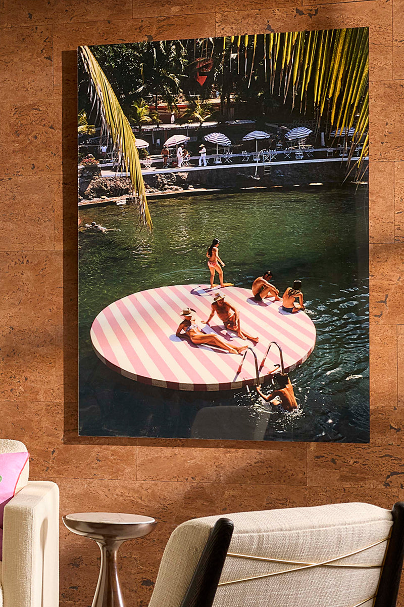 Slim Aarons photograph of pool loungers on red and white striped raft