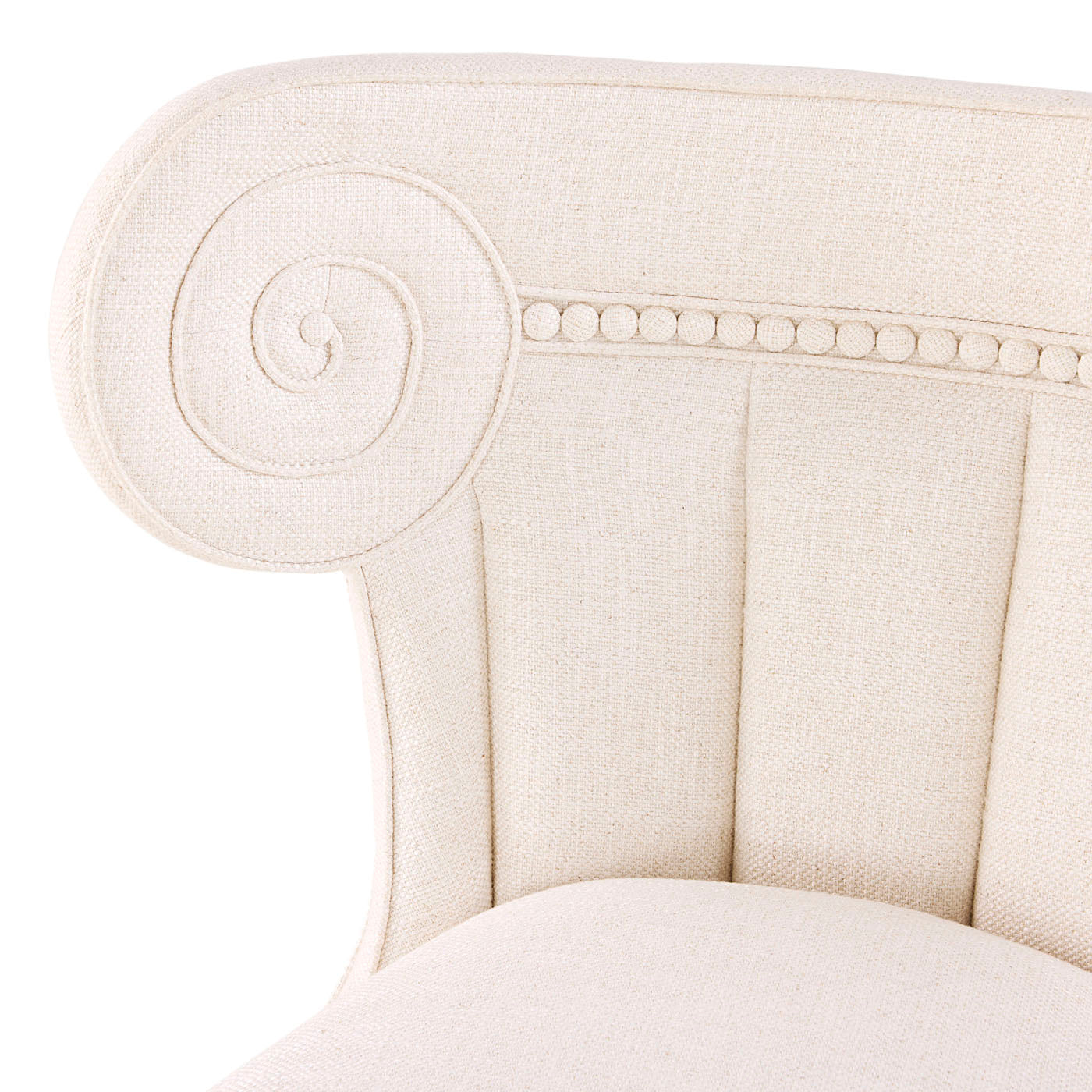 Close-up of a cream-colored upholstered chair with decorative nailhead trim on a white background