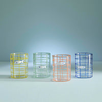 Four colorful glass tumblers with wireframe designs on a light blue background