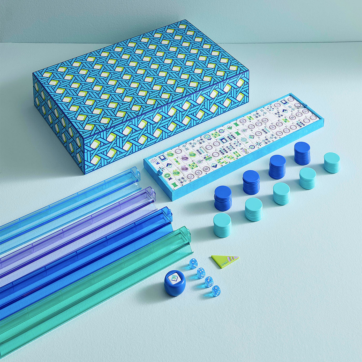 Colorful geometric toy set with blue, green, and purple components on a light blue background.