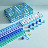 Colorful geometric toy set with blue, green, and purple components on a light blue background.
