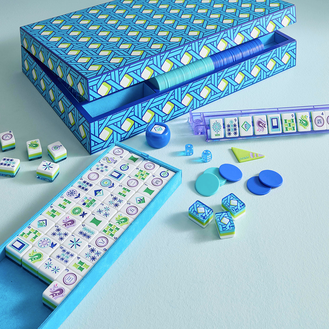 Mahjong game set with tiles and components on a light blue background