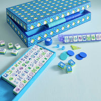 Mahjong game set with tiles and components on a light blue background