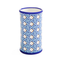 A cylindrical ceramic cup or candle holder with a blue and white geometric interlocking pattern, featuring a solid blue rim and base, set against a plain white background.