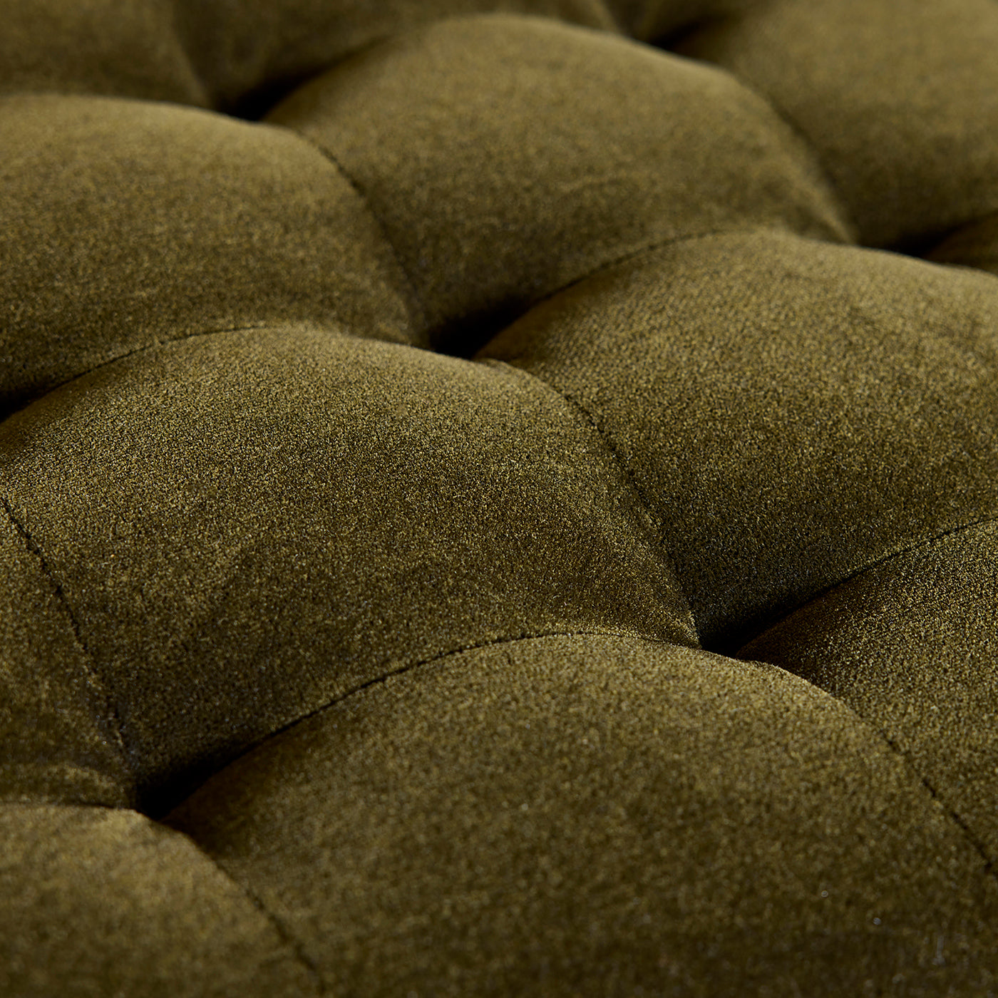 Close-up of a green textured fabric with tufted design