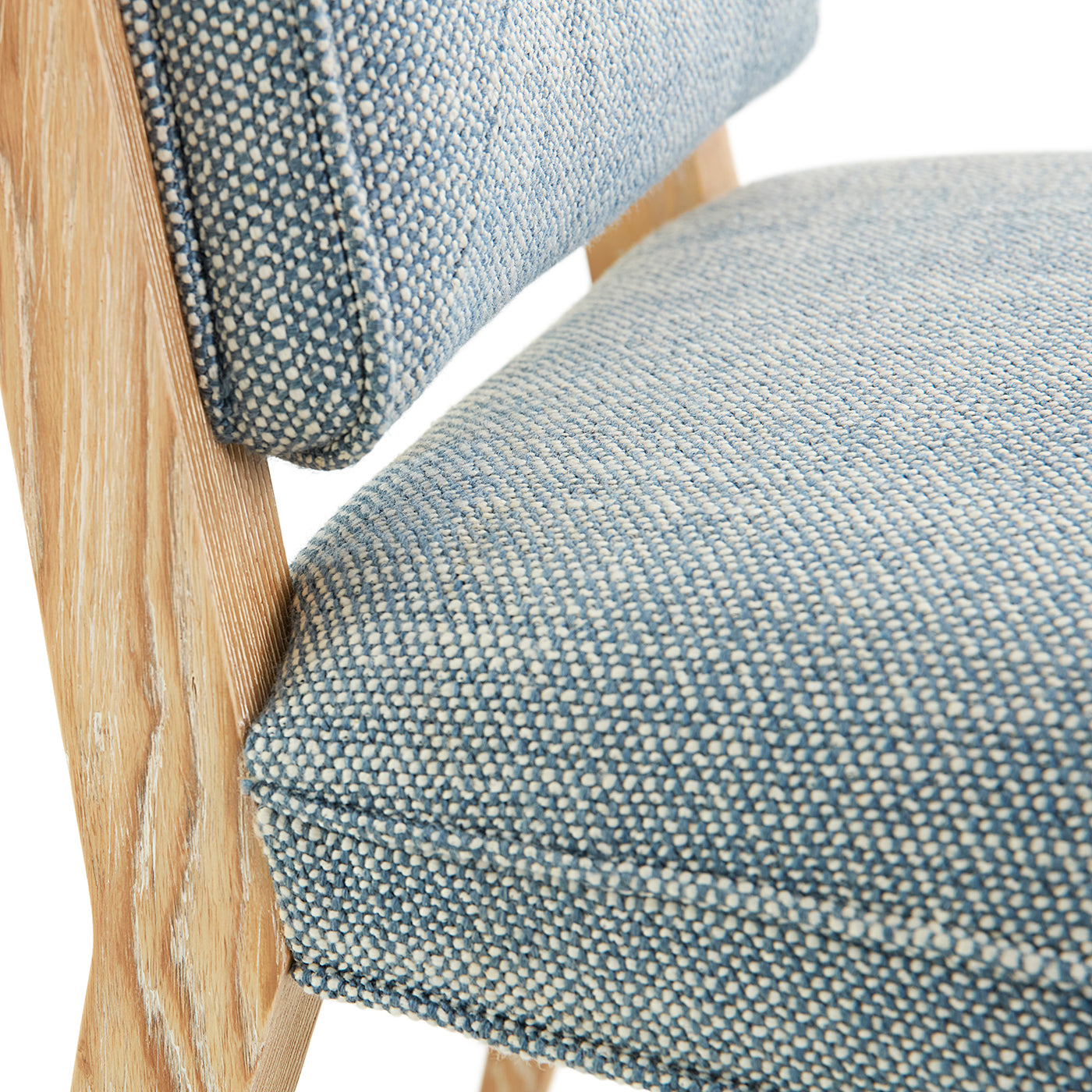 Close-up of a chair with blue patterned fabric seat and wooden frame.