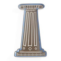 A decorative enamel pin shaped like a classical column, featuring a brown body with white line details and a blue border, set against a plain white background.
