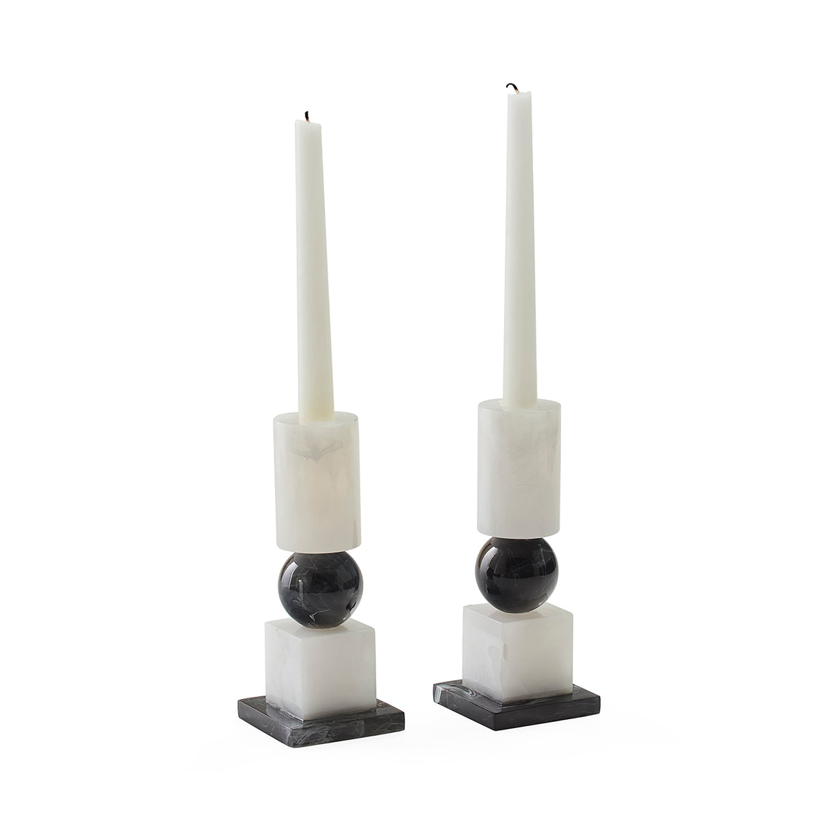 side angle view of set of two black and white candle stick holders styled with white candlesticks (not included) 