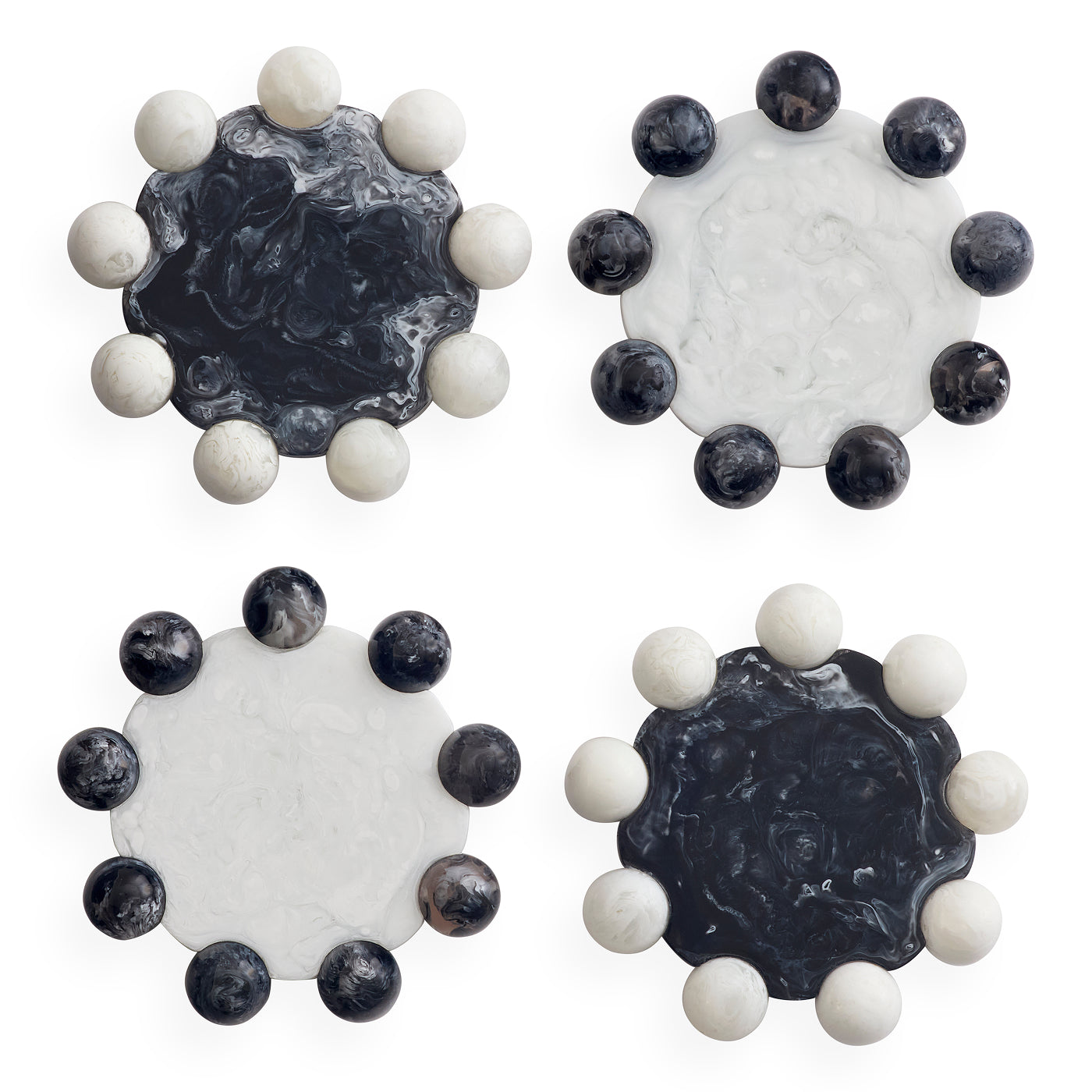 Four round decorative coasters arranged in a 2x2 grid on a white background. Each coaster features a central marbled stone disc in black, white, or dark gray tones, surrounded by a ring of smooth spherical beads in white and dark gray.