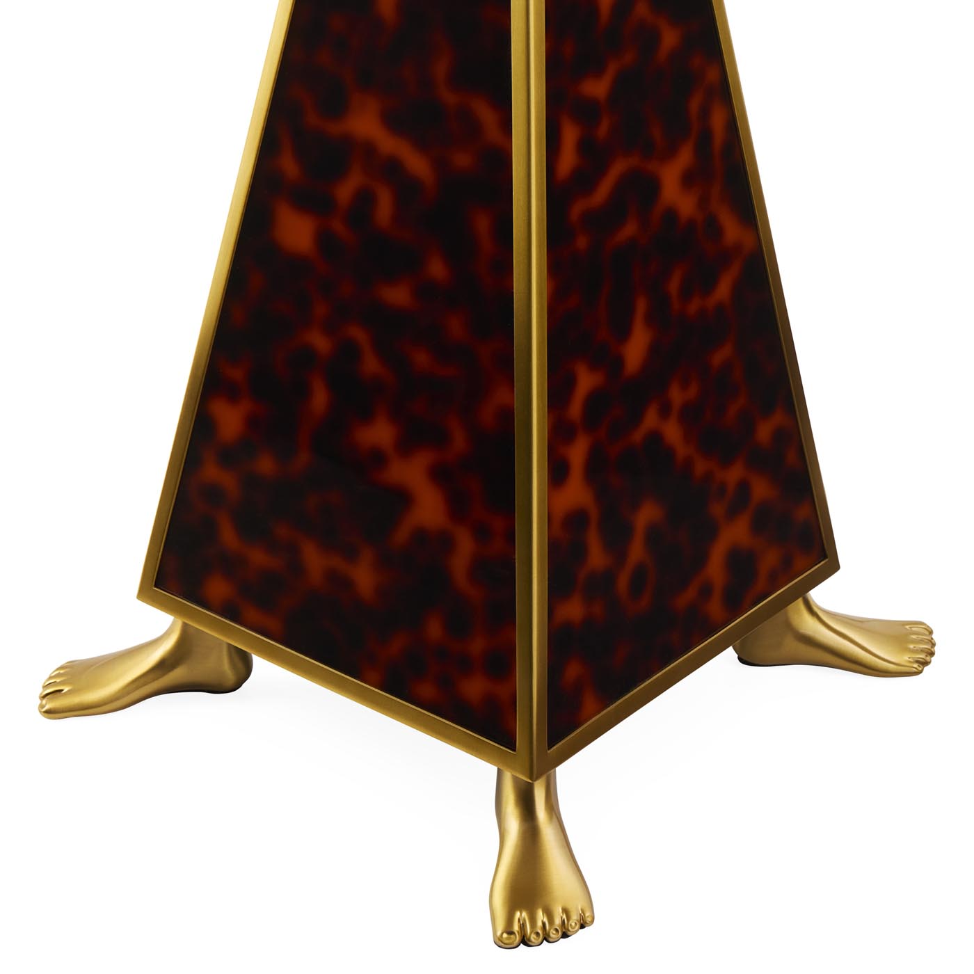 Decorative object with tortoiseshell pattern and gold feet on a white background