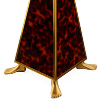 Decorative object with tortoiseshell pattern and gold feet on a white background
