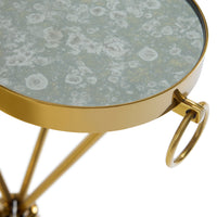 Close-up of a round side table with a distressed gray-green marble-patterned top and a polished gold metal frame and tripod base, featuring a side ring handle.