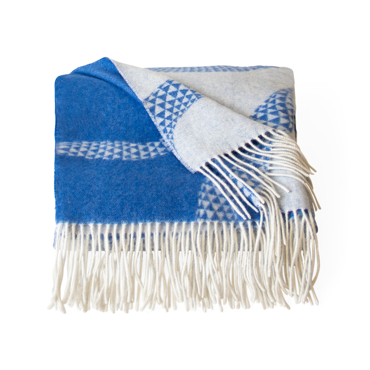 A folded woven throw blanket with fringe, featuring a bold blue and off-white geometric pattern on a clean white background.