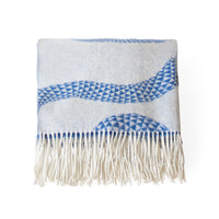 A square woven throw blanket with cream-colored fringe, featuring a light blue and white geometric pattern with blue accents.