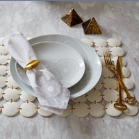 White ceramic plates with gold accents on a decorative surface